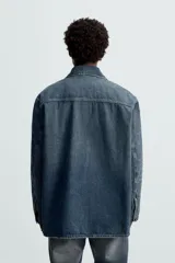 Sobrecamisa relaxed fit confeccionada en denim de algodón con efecto lavado. Tiene cuello solapa, manga larga, bolsillos frontales de plastrón y cierre frontal de botonadura.
