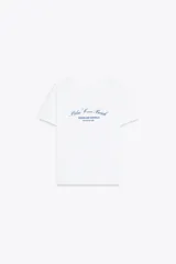 Camiseta blanca de algodón con cuello redondo y mangas cortas. Estampado frontal con texto en azul marino que dice "Palm Cove Beach Queensland Australia 1989 Social Club".