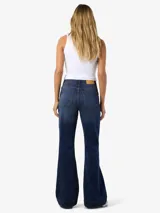 Jean de tiro alto, corte slim flare, en denim de sarga color azul medio con efecto levemente desgastado. Presenta cierre de botón y cremallera.