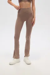 Calza gris de corte ajustado y tiro alto, con textura acanalada y terminación acampanada.