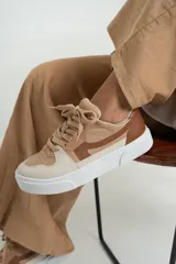 Zapatillas de cuero con diseño en tonos beige y marrón, equipadas con plantilla acolchada para mayor comodidad.