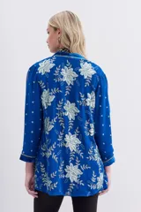 Saco azul eléctrico de viscosa con terminaciones en velvet, bordado con lentejuelas e hilo de lurex. Tiene calce recto, mangas largas y forro interior de jacquard.
