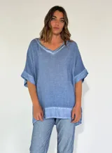 Blusa celeste de lino con cuello en V y mangas cortas amplias.
