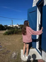 Remera de manga larga con diseño holgado, confeccionada en tejido de punto a rayas horizontales en tonos rosado y marrón.