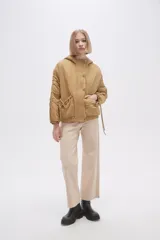 Campera negra de manga larga con capucha, cierre frontal con botones a presión, bolsillos laterales y cordón ajustable en la cintura.