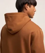 Buzo marrón de algodón y poliéster, con capucha, cordón ajustable, bolsillo canguro y estampa con lettering.