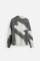 Jersey de punto gris con efecto tie-dye blanco, de corte relaxed fit, cuello redondo y mangas largas.