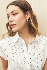 Camisa negra con broderie, de manga corta, calce relajado, cuello clásico, abotonada al frente y con lazo regulable en la cintura.