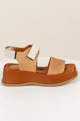 Sandalias de cuero color marrón con plataforma, tira ancha sobre los dedos y tira trasera con ajuste de velcro.