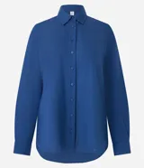 Camisa color ladrillo confeccionada en viscolino, de corte alargado, con cuello clásico, mangas largas, bolsillo delantero y cierre frontal con botones.