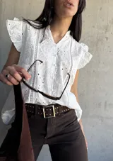 Blusa blanca con bordado inglés, cuello mao, mangas cortas con volados y cierre frontal con botones.