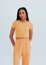 Blusa cropped básica de tela acanalada, con silueta ajustada y mangas cortas.