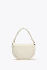 Bolso de hombro ovalado color crema con asa de doble tira redonda con detalles metalizados dorados. Incluye cierre imantado, asa de bandolera extraíble con tejido a contraste y bolso interior con cierre mediante cremallera metálica.