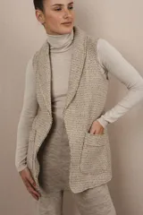 Chaleco color beige, entallado, con solapa, bolsillos plaqué y terminaciones envivadas.