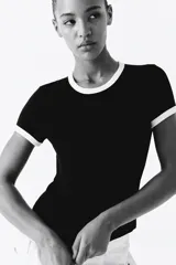 Remera negra entallada de punto suave con cuello y mangas con ribete blanco.