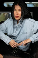 Camisa de jean celeste de corte oversize, con cuello clásico, cierre frontal con botones, bolsillo en el pecho y mangas largas con puños abotonados. Detalle de bordado en el puño.