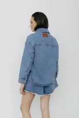 Campera de jean celeste con bolsillos frontales y botones metálicos.
