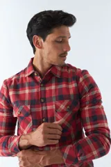 Sobrecamisa de algodón para hombre con interior de corderito, estampado a cuadros en tonos negro, blanco y azul. Tiene cierre de botones, bolsillos tipo cartera y logo en goma. El modelo usa talle M.
