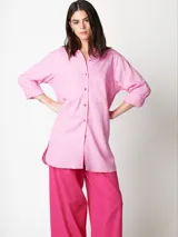 Camisa oversized color rosado, con largo por debajo de la cadera, mangas largas y bolsillo con detalle bordado.