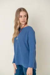 Sweater de lana color beige, de corte holgado y mangas largas.