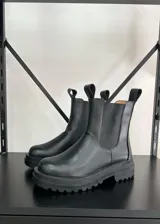 Botas cortas de cuero vegano color negro, con elástico lateral y suela track.