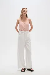 Pantalón de jean color beige, de tiro alto, corte palazzo y estilo paper bag.