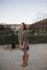 Botas de caña alta color arena, de gamuza, con taco ancho y punta semi cuadrada. Presentan un estribo de hebilla forrada y botón a presión. La caña es desmontable y se transforma en bota corta.