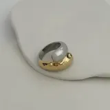 Anillo de acero quirúrgico hipoalergénico con baño en oro de 18K. Diseño con forma irregular en dos tonos: dorado y plateado.