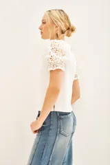 Remera blanca de algodón con mangas balloon de broderie, cuello redondo y tajos laterales.
