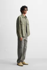 Sobrecamisa verde militar de algodón con estructura canvas, corte relaxed fit, cuello solapa, manga larga con puños abotonados, bolsillos frontales de plastrón con solapa, efecto lavado y cierre frontal con botones.