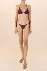 Calzón de bikini color violeta con tiritas laterales ajustables y detalle de cuentas doradas en los extremos.