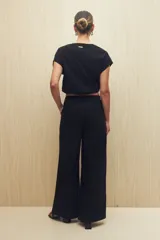 Pantalón color beige de corte ancho y tiro alto, con bolsillos delanteros amplios.