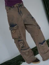 Pantalón cargo de jean color marrón con efecto desgastado, múltiples bolsillos funcionales y detalles metálicos en bronce.