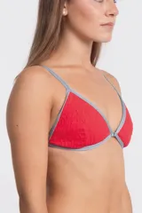 Corpiño de bikini triangular color rojo con textura arrugada y bordes ribeteados en gris claro. Presenta un pequeño aro metálico en el centro del escote.