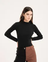 Polera de tejido suave color negro, con cuello alto y corte ajustado al cuerpo.