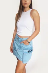 Minifalda de jean celeste con bolsillos cargo y parche con logo de la marca en el lateral.