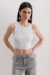 Musculosa gris jaspeado con cuello redondo y bordado de una margarita en el centro.