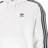 Hoodie (canguro) Adidas Originals blanco con capucha ajustable y bolsillo canguro frontal. Presenta el logo del trébol bordado en el pecho y las icónicas tres franjas negras a lo largo de las mangas.