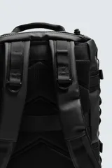 Mochila negra fabricada en tejido técnico. Tiene un compartimento principal con cierre mediante hebillas de liberación rápida y cremallera, un bolsillo interior con cierre, parte posterior acolchada con banda de sujeción para equipaje, dos asas de mano y dos asas de hombro ajustables.