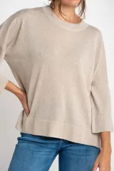 Sweater color cobre brillante, de tejido de punto con lurex, corte oversize, cuello redondo y mangas 3/4 con volados.
