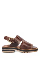 Sandalia de cuero marrón oscuro, estilo pescador cerrado en la punta y abierto en el talón con tira ajustable y hebilla dorada. Presenta costuras blancas visibles y suela de goma gruesa con plataforma y taco bajo.