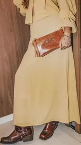 Cartera de mano tipo clutch, color marrón, confeccionada en cuero.