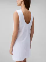 Vestido corto blanco de popelín de algodón, corte evasé y diseño sin mangas. Cuenta con cremallera en la parte trasera central, está parcialmente forrado y tiene bordado de Calvin Klein en la misma gama de tonos en el pecho.