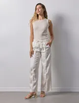 Pantalón palazzo color crudo, marca Nanette, con pretina elastizada, lazo de ajuste y bolsillos delanteros.