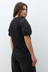 Remera negra de algodón con cuello redondo y mangas cortas abullonadas.