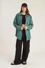 Pantalón de calce ancho y fluido en color negro, confeccionado en tejido de cupro. Presenta bolsillos laterales tipo cargo y un diseño de tiro alto.