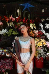 Conjunto deportivo blanco con estampado geométrico en gris, compuesto por un top corto con breteles finos y un short ajustado.