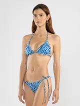 Conjunto de bikini azul con estampado animal print y rayas. El top es de triángulo con tiras finas que se atan al cuello y a la espalda. La bombacha es de corte clásico con tiras laterales.