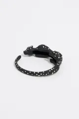 Pulsera rígida negra con forma de pantera con incrustaciones de strass blancos y rosados.