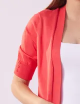 Cardigan tejido color beige, manga corta con apliques de botones.